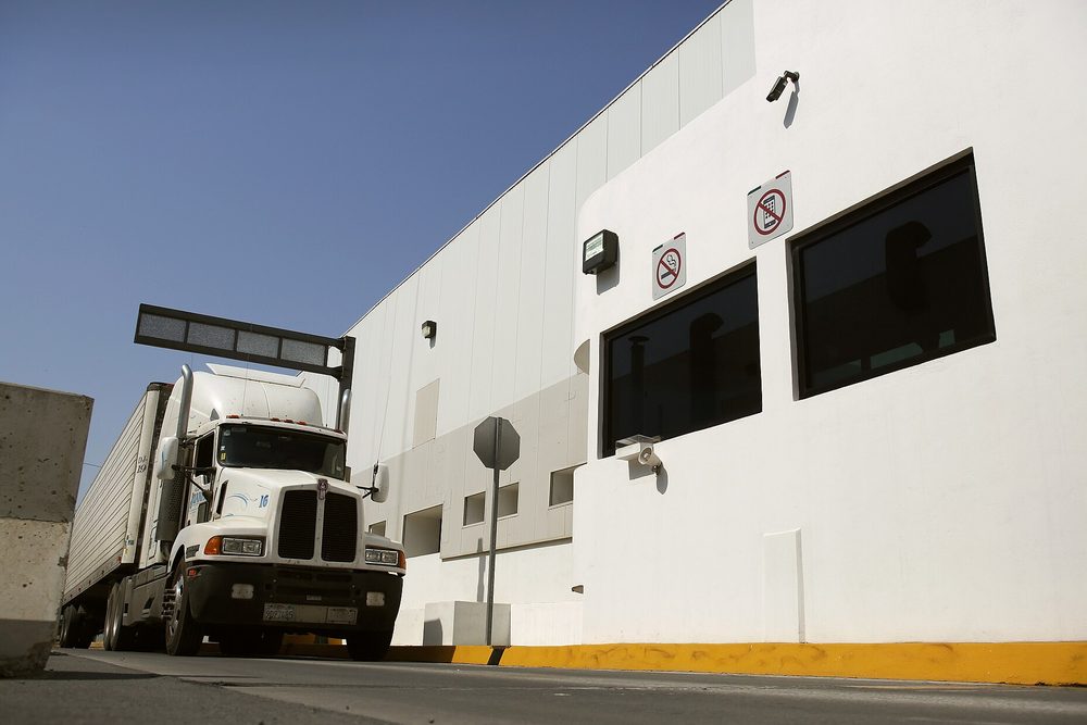 A tractor trailer pulling up to an inspection facility at a border crossing